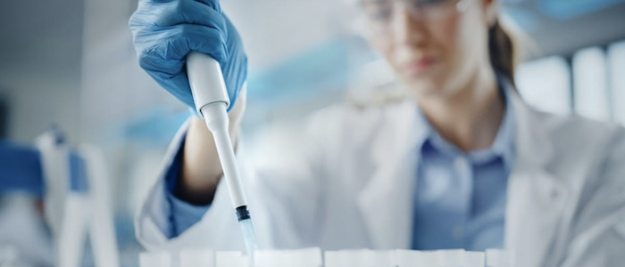 Female scientist fills test tubes.